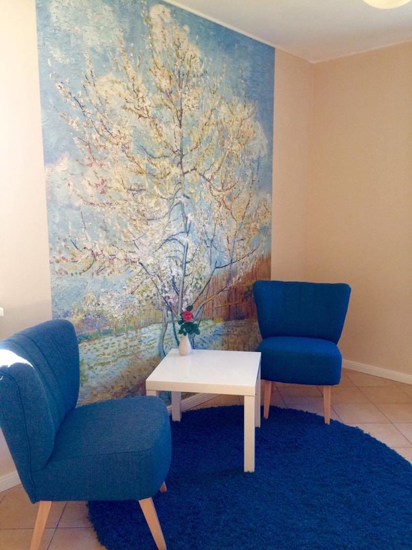 Heller Therapieraum mit zwei blauen Sesseln und einem kleinen Tisch